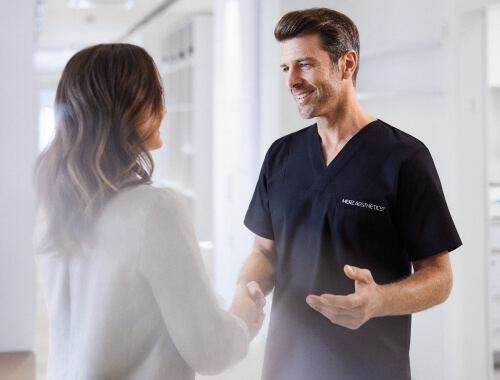 arzt begrüßt patientin mit händedruck